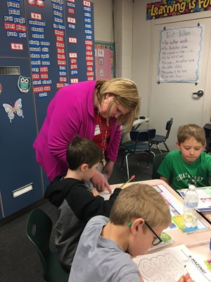 Employee of CSB works with second grade JVES student on banking